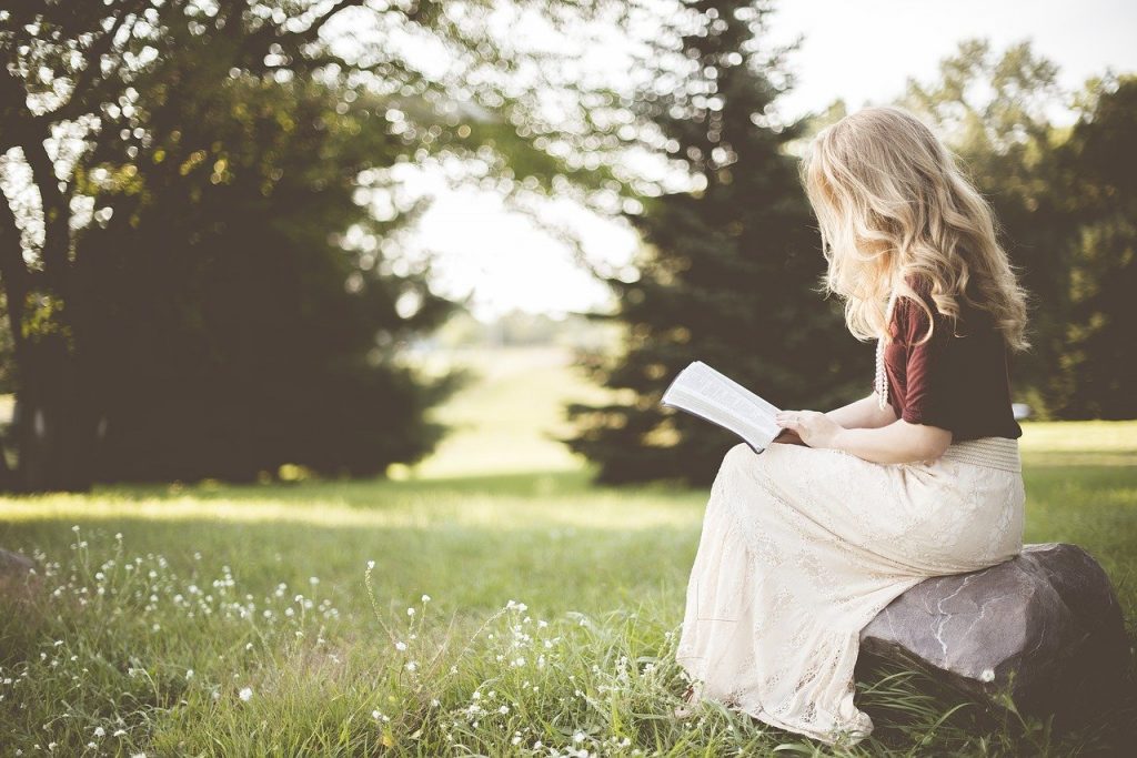 Meisje leest boek in het park